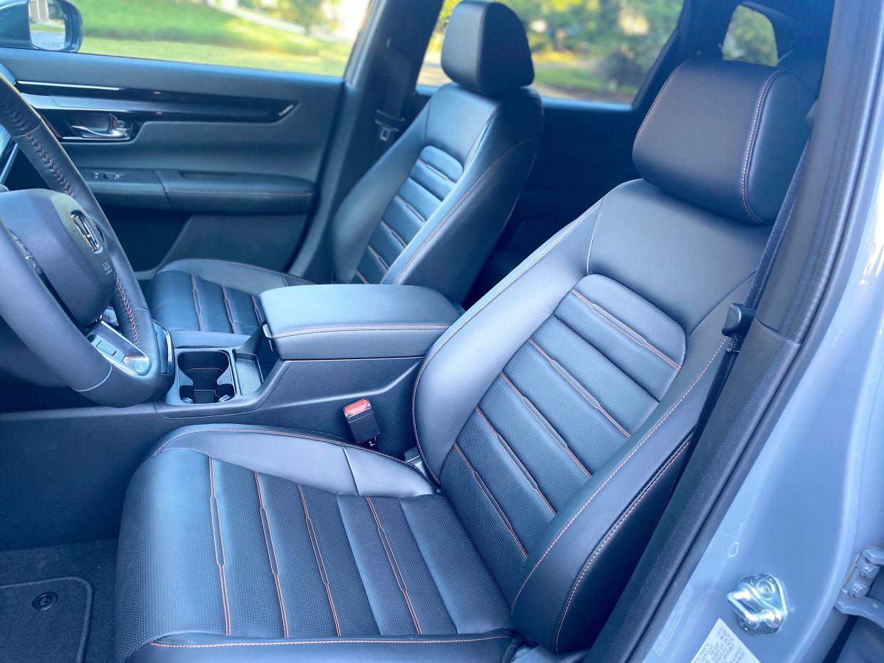 The black leather driver seat with red stitching in a gray 2025 Honda CR-V Hybrid Sport Touring SUV.