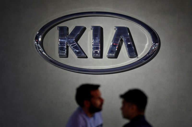 Visitors walk past the logo of Kia Motors at its pavilion at the India Auto Expo 2020 in Greater Noida