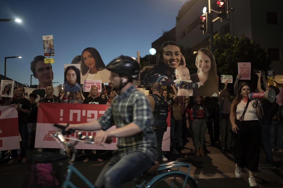 Families and their supporters carry large photos depicting women held hostage by Hamas in the Gaza Strip in a march to call on Israeli Prime Minister Benjamin Netanyahu's government to make a deal to free their loved ones, in Tel Aviv, Israel, Wednesday, May 8, 2024. (AP Photo/Maya Alleruzzo)