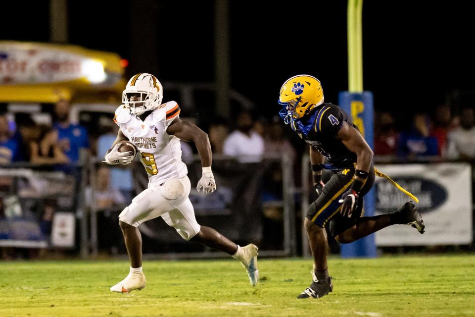 Hawthorne Hornets running back Keenon Johnson (9) runs with the ball after a catch trying to escape Newberry Panthers linebacker Logan Mccloud (4) during the first half at Newberry High School in Newberry, FL on Friday, September 1, 2023. [Matt Pendleton/Gainesville Sun]