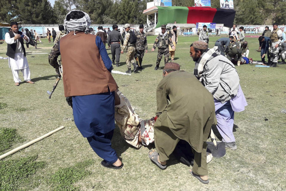 A wounded man is carried away following multiple explosions in Lashkar Gah city of Helmand province, southern Afghanistan, Saturday, Mar. 23, 2019. An Afghan official says that at least three have been killed in twin bomb explosions occurred during the Farmer’s Day ceremony in southern Helmand province. (AP Photo/Abdul Khaliq)