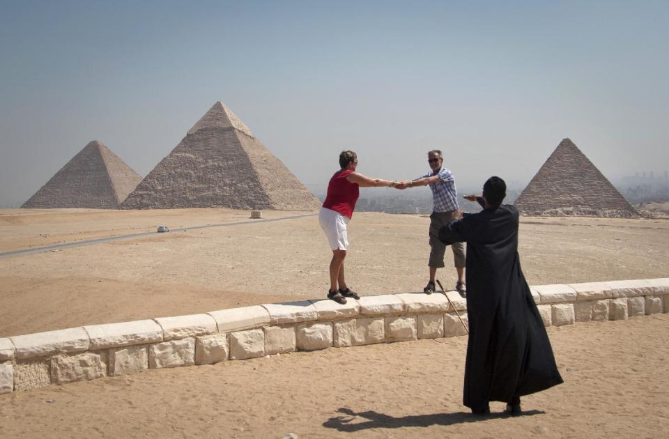 In this Thursday, Sept. 27, 2012 photo, foreign tourists visit the historical site of the Giza Pyramids, near Cairo, Egypt. The Egyptian demonstrations against an online film that was produced by a U.S. citizen originally from Egypt and denigrates the Prophet Muhammad were part of a wider explosion of anger in Muslim countries. They happened near the U.S. Embassy, far from the pyramids of Giza on Cairo's outskirts, and a lot further from gated Red Sea resorts, cocoons for the beach-bound vacationer. Yet the online or TV images _ flames, barricades, whooping demonstrators _ are a killjoy for anyone planning a getaway, even though the protests have largely subsided. Tour guides in Egypt say tourist bookings are mostly holding, but they worry about a dropoff early next year, since people tend to plan several months ahead.(AP Photo/Khalil Hamra)