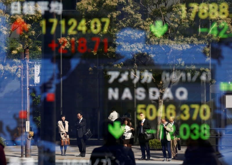People are reflected in a display showing the Nikkei average (top in L) and the NASDAQ average of the U.S outside a brokerage in Tokyo, Japan, November 7, 2016. REUTERS/Kim Kyung-Hoon - S1AEULJVTGAA