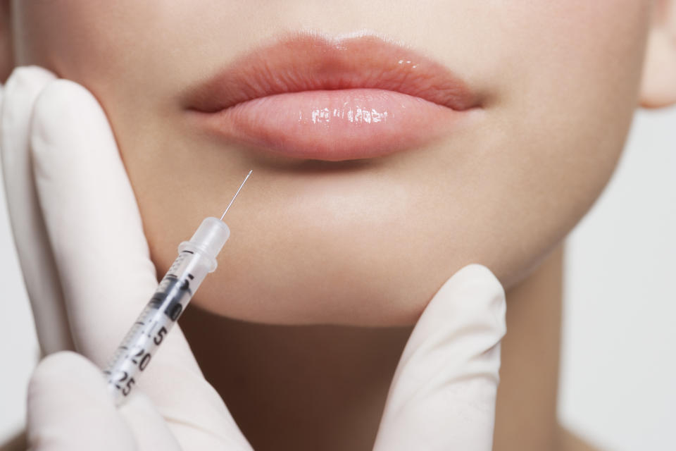As shot of a woman's lips with a needle