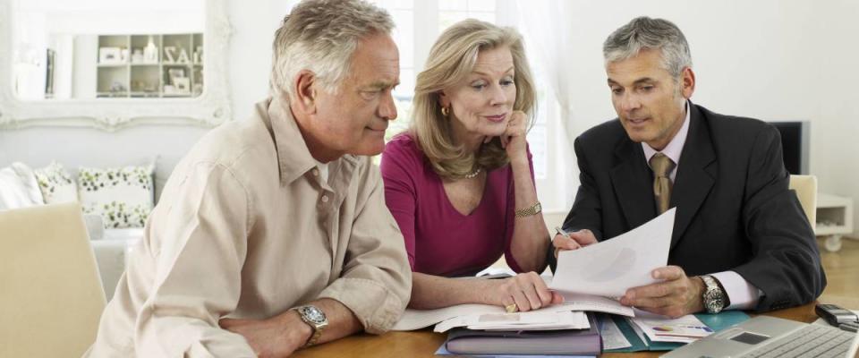 Mature couple sitting at table with financial advisor