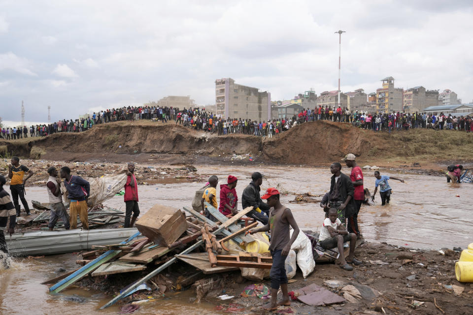 Residents watch as excavators and bulldozers bring down their homes in the Mathare area of Nairobi, Kenya, Wednesday, May. 8, 2024. The Kenyan government last week ordered evacuations and the demolition of structures and buildings that had been built illegally within 30 meters of river banks. But the demolitions have only led to more suffering as those affected say they are being carried out in a chaotic and inhumane way. (AP Photo/Brian Inganga)