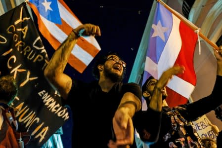 Demonstrators chant and wave Puerto Rican flags during the fourth day of protest calling for the resignation of Governor Ricardo Rossello in San Juan