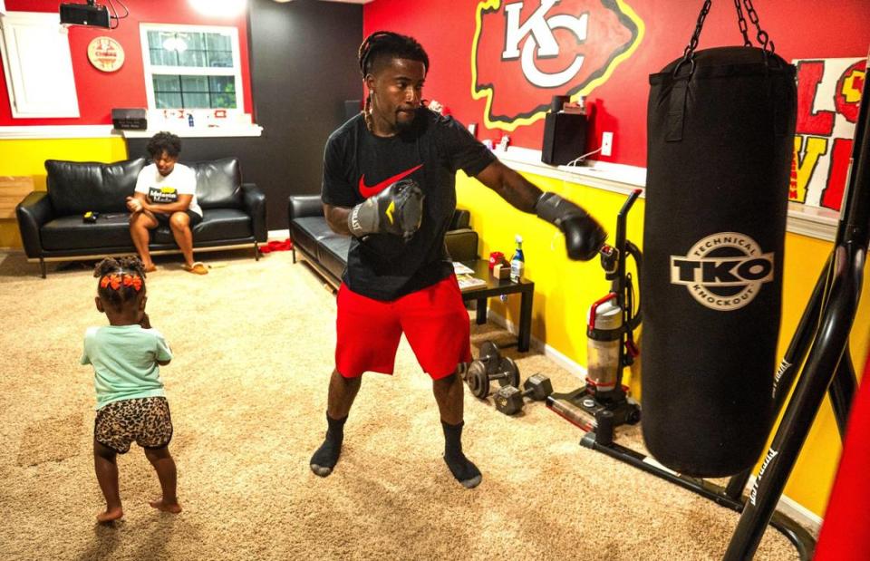 A heavy bag endures punches from John Roddy while his wife Mika and their daughter Esrael play nearby in their Blue Springs home. Zachary Linhares/The Kansas City Star