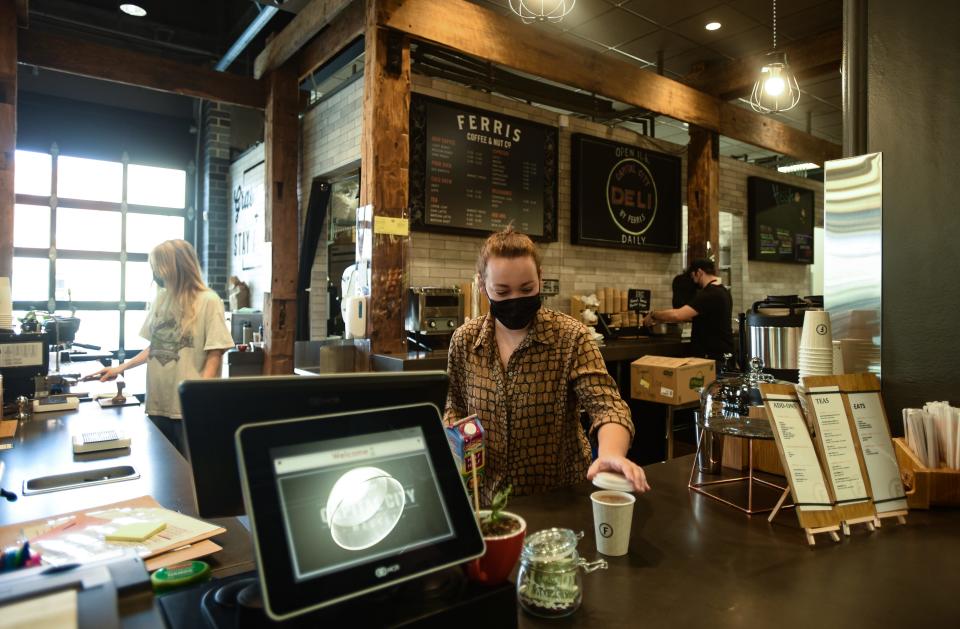 Barista Taylor Walker of Ferris Coffee & Nut Co. serves a coffee at the downtown Capital City Market Tuesday, Sept. 7, 2021.