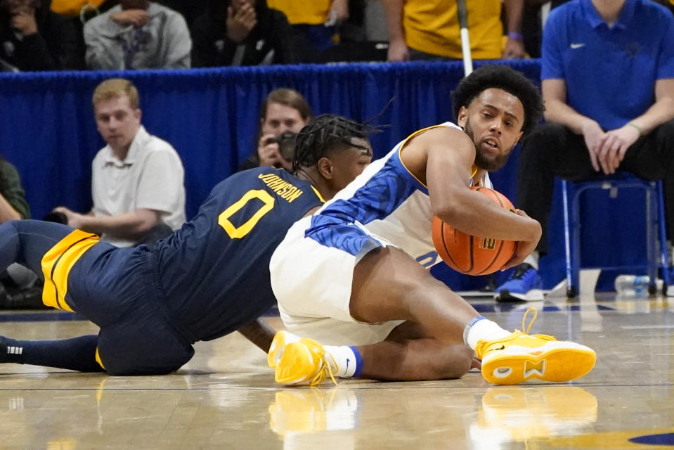 Pittsburgh's Nelly Cummings, right, tries to control the ball from the floor in front of West Virginia's Kedrian Johnson, left, during the first half of an NCAA college basketball game, Friday, Nov. 11, 2022, in Pittsburgh. (AP Photo/Keith Srakocic)
