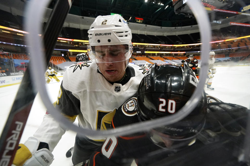 Vegas Golden Knights defenseman Zach Whitecloud, left, pushes Anaheim Ducks left wing Nicolas Deslauriers into the boards during the second period of an NHL hockey game Saturday, Feb. 27, 2021, in Anaheim, Calif. (AP Photo/Mark J. Terrill)