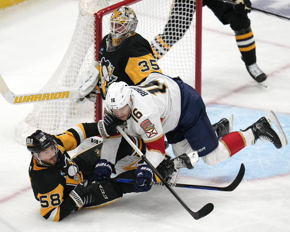 Florida Panthers' Aleksander Brakov (16) collides with Pittsburgh Penguins' Kris Letang (58) in front of goalie Tristan Jarry (35) during the first period of an NHL hockey game in Pittsburgh, Wednesday, Feb. 14, 2024. (AP Photo/Gene J. Puskar)