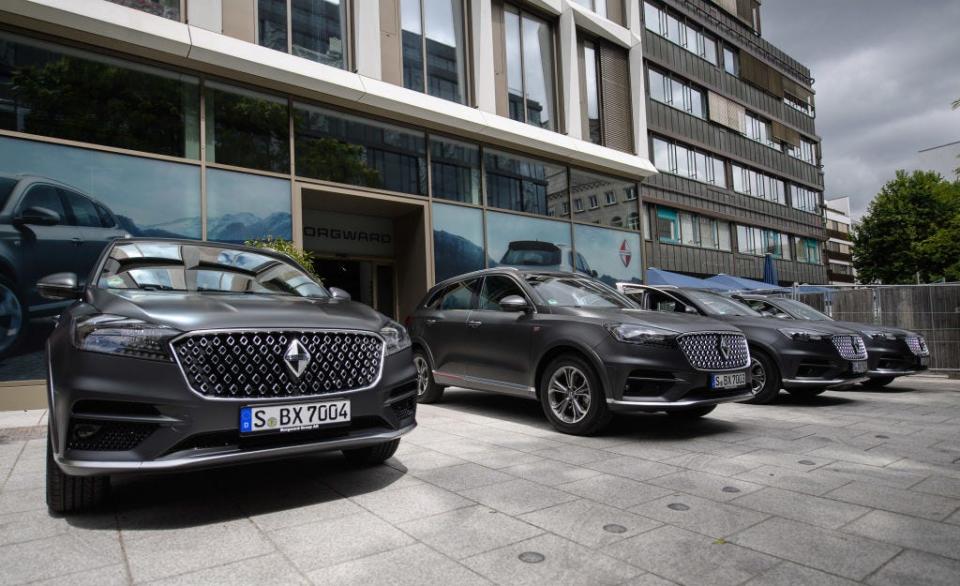 A row of gray Borgward BX7 SUVs parked in front a dealership in Germany