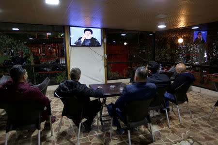 People watch Lebanon's Hezbollah leader Sayyed Hassan Nasrallah as he speas on television in Beirut, Lebanon November 20, 2017.REUTERS/ Jamal Saidi