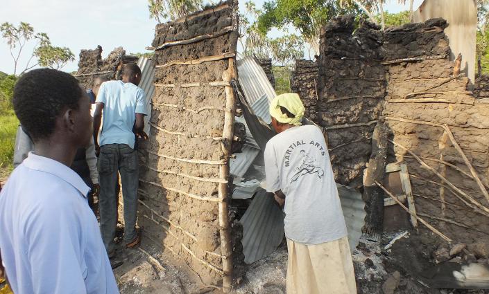 Residents of Kenya's coastal Lamu region gather on July 6, 2014 around a house that was burnt down during an attack the night before (AFP Photo/)