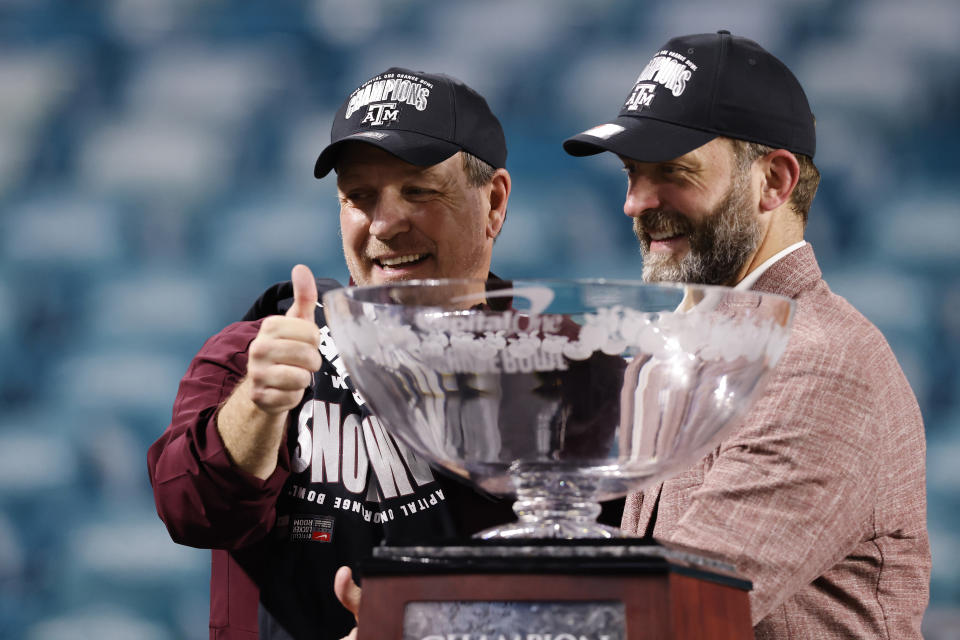 MIAMI GARDENS, FLORIDA - JANUARY 02: Head coach Jimbo Fisher and athletic director Ross Bjork of the Texas A&M Aggies pose for a photo with the trophy after defeating the North Carolina Tar Heels 41-27 in the Capital One Orange Bowl at Hard Rock Stadium on January 02, 2021 in Miami Gardens, Florida. (Photo by Michael Reaves/Getty Images)