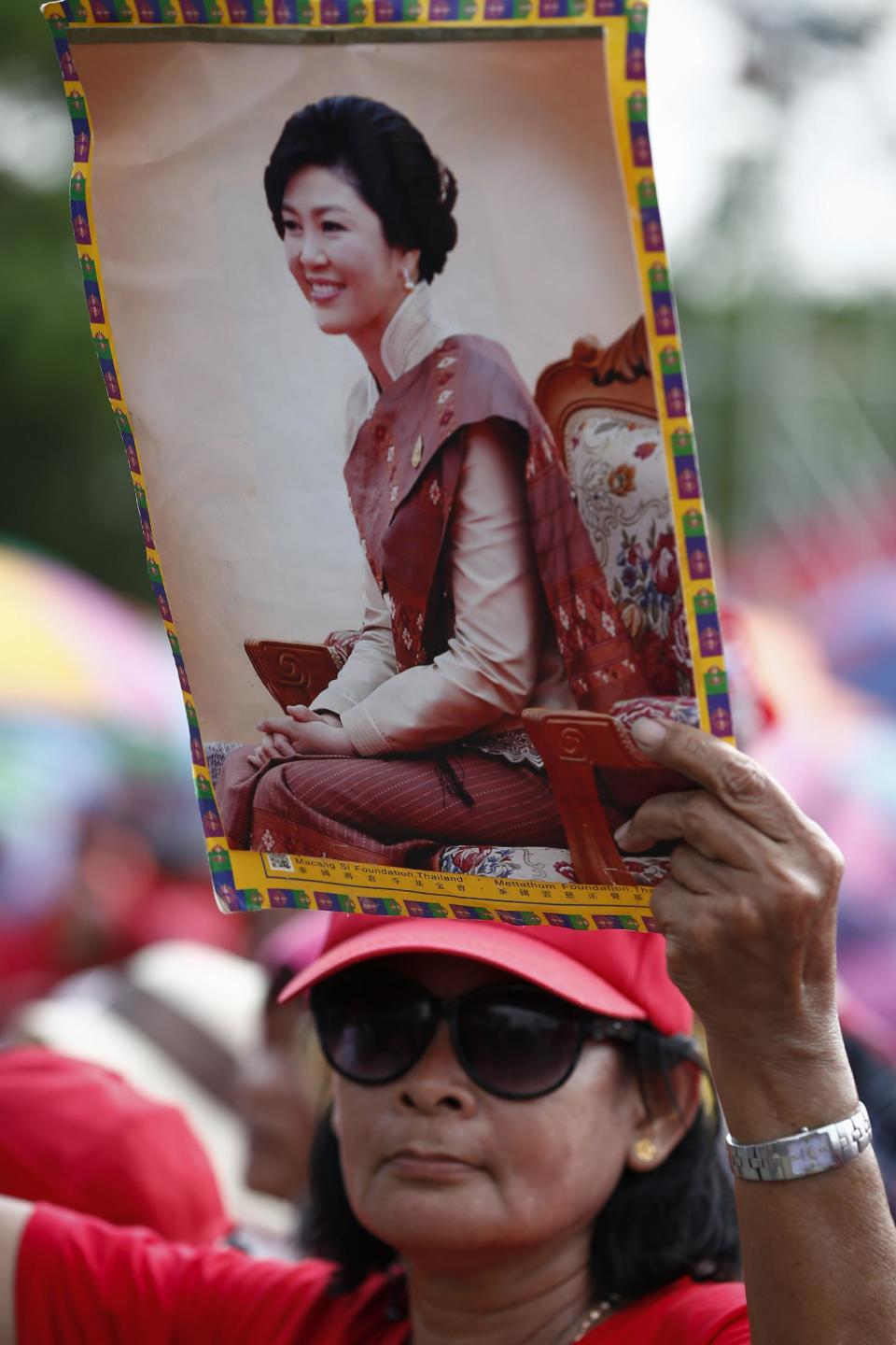 A pro-government protester holds up a portrait of the ousted Prime Minister Yingluck Shinawatra during a rally in Aksa, outskirt of Bangkok, Thailand, Saturday, May 10, 2014. Supporters of Thailand's embattled government streamed into western Bangkok for a show of force Saturday that follows Shinawatra's ouster and a renewed push by rival demonstrators to install an unelected premier. (AP Photo/Vincent Thian)