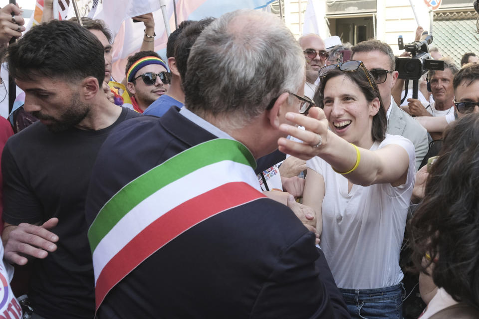 Rome Mayor Roberto Gualtieri, back to camera, is greeted by Democratic party leader Elly Schlein as they take part in the LGBTQ+ Pride parade in Rome, Saturday, June 10, 2023. Rome's annual LGBTQ+ Pride parade is winding its way through the Italian capital. This year's version provides a counterpoint to the right-wing national government's crackdown on surrogate pregnancies. Earlier this year, the government headed by far-right Premier Giorgia Meloni told municipal officials to refrain from recording both members of a same-sex couple as the parent of the child, only the biological parent. Among those who have defied that order was center-left Rome Mayor Roberto Gualtieri, who came to Saturday's parade. (Mauro Scrobogna/LaPresse via AP)