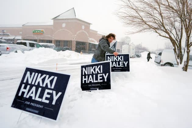A campaign worker posts signs Tuesday before a campaign event for Republican presidential candidate Nikki Haley at Mickey's Irish Pub in Waukee, Iowa.