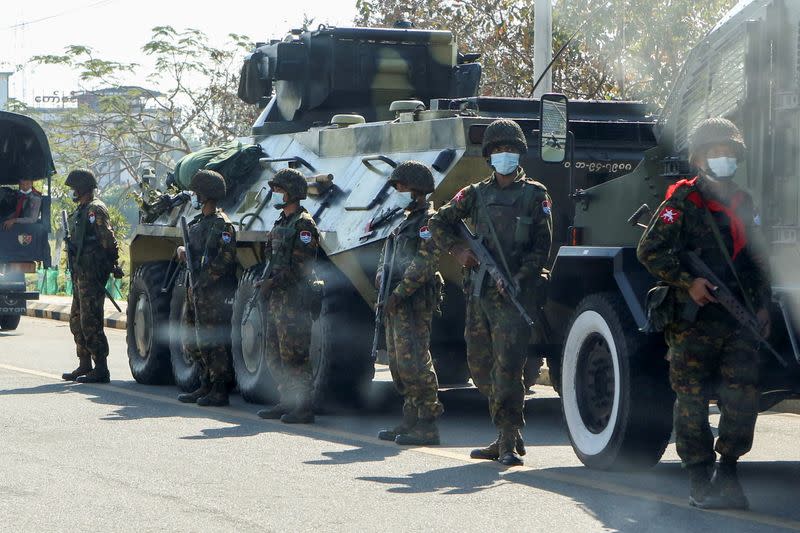 Soldiers stand guard next to armored vehicles in Naypyitaw
