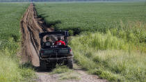 <p>Leflore County Coroner Debra Sanders, right, rides Tuesday, July 11, 2017, with a sheriff’s deputy into a restricted area north of U.S. Highway 82, near a site that has part of the wreckage of a military plane that crashed Monday in a farm field, in Itta Bena, Miss. (Photo: Rogelio V. Solis/AP) </p>