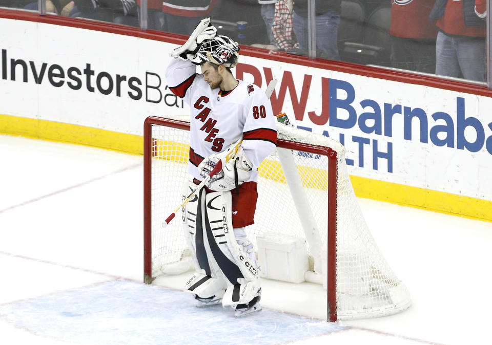 Carolina Hurricanes goaltender Jack LaFontaine (80) reacts after giving up a goal to the New Jersey Devils during the third period of an NHL hockey game, Saturday, Jan. 22, 2022, in Newark, N.J. (AP Photo/Noah K. Murray)