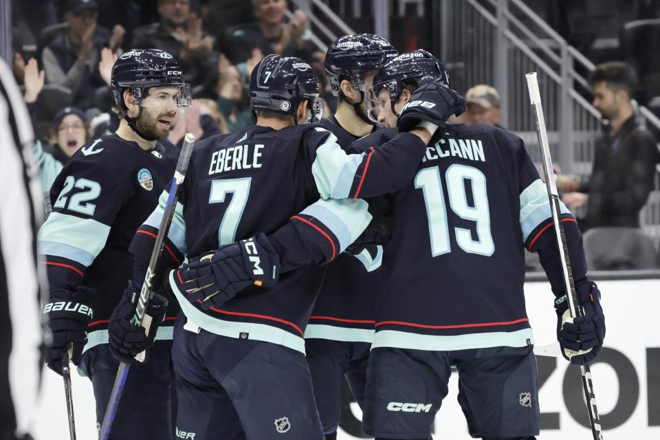 Seattle Kraken right wing Jordan Eberle (7) is congratulated by left wing Jared McCann (19) and right wing Oliver Bjorkstrand (22) after scoring against the Columbus Blue Jackets during the first period of an NHL hockey game, Sunday, Jan. 28, 2024, in Seattle. (AP Photo/John Froschauer)