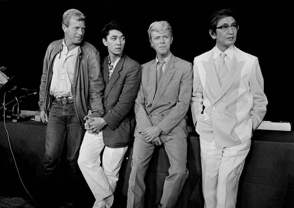 FILE - The team that created the film "Merry Christmas, Mr. Lawrence" is pictured in Paris, May 11, 1983. From left: Jack Thomas, producer; Ryuichi Sakamoto, musical composer; David Bowie, star, and Nagisa Oshima, director. Japan's recording company Avex says Sakamoto, a musician who scored for Hollywood movies such as “The Last Emperor” and “The Revenant,” has died. He was 71. He died March 28, according to the statement released Sunday, April 2, 2023. (AP Photo/Jacques Langevin, File)