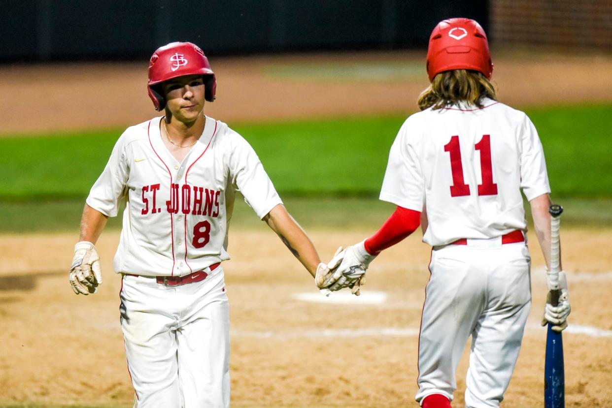 St. Johns' Brandon Schomisch, left, celebrates his run with Seth Shank during the third inning in the game against Grand Ledge on Wednesday, May 31, 2023, at McLane Stadium on the Michigan State campus in East Lansing.