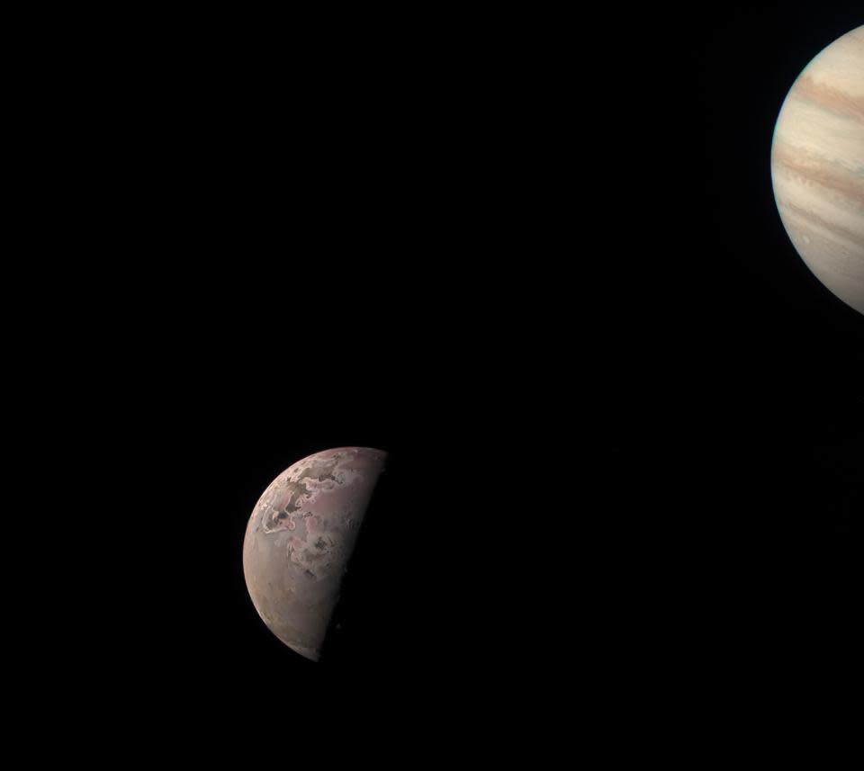 a ringed planet can be seen in the foreground, while a small grey moon can be seen in the background