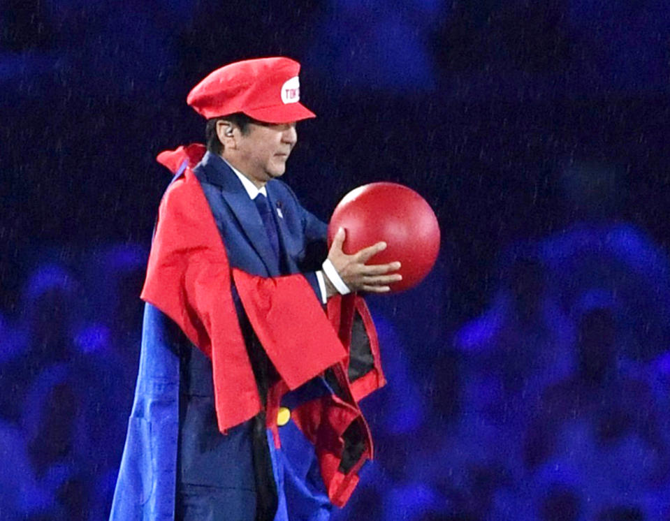 FILE - In this Aug. 21, 2016, file photo, Japanese Prime Minister Shinzo Abe appears as the Nintendo game character Super Mario during the closing ceremony at the 2016 Summer Olympics in Rio de Janeiro, Brazil. Prime Minister Abe might be the biggest loser if the Tokyo Olympics don't go off as planned in just over four months. Abe has attached himself to the success of the Olympics since pushing hard for Tokyo's selection at an IOC meeting in 2013 in Buenos Aires, Argentina. Tokyo was picked over Istanbul by billing itself as a “safe pair of hands." (Yu Nakajima/Kyodo News via AP, File)