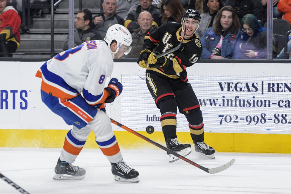 Vegas Golden Knights right wing Reilly Smith (19) shoots past New York Islanders defenseman Noah Dobson (8) during the second period of an NHL hockey game Saturday, Dec. 17, 2022, in Las Vegas. (AP Photo/Sam Morris)