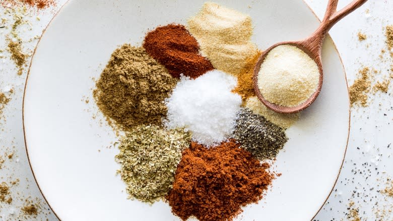 Top-down view of chili powder blend spices on a plate with a spoon