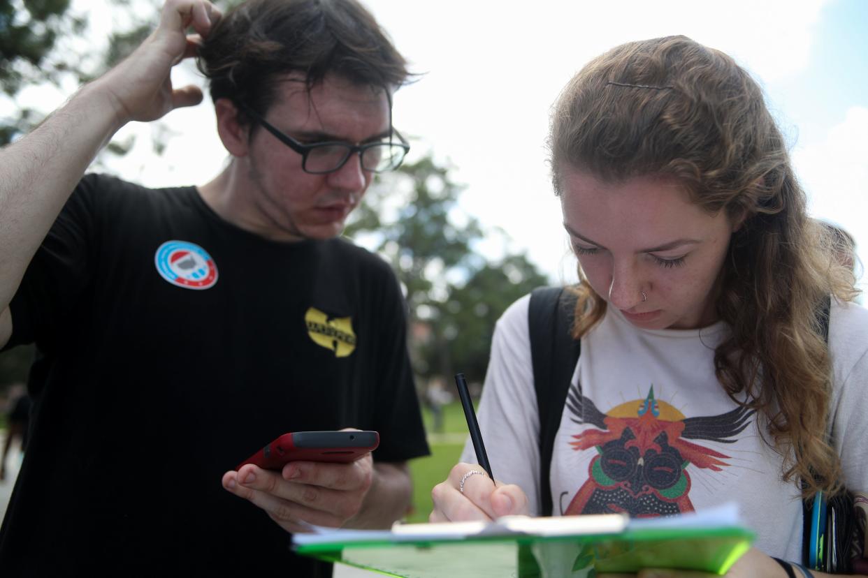 Dylan McMahon, left, an FSU sophomore helps Lindsey Kirkland, a junior, register to vote at her new dorm address on the FSU campus in Tallahassee, Fla. Tuesday, Sept. 25, 2018. McMahon is a part of the Florida New Voters Project, volunteering time on campus with a group of others to get students and passersby to fill out a registration document in Landis Square. The group is non-partisan, focusing solely on registering young voters on college campuses. 