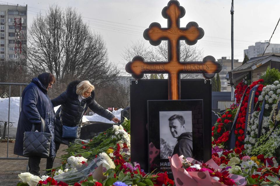 La madre del opositor ruso Alexei Navalny, Lyudmila Navalnaya (izquierda), y la suegra visitan su tumba un día después de su entierro, en el cementerio Borisovskoye, en Moscú, Rusia, el 2 de marzo de 2024. (AP Foto)