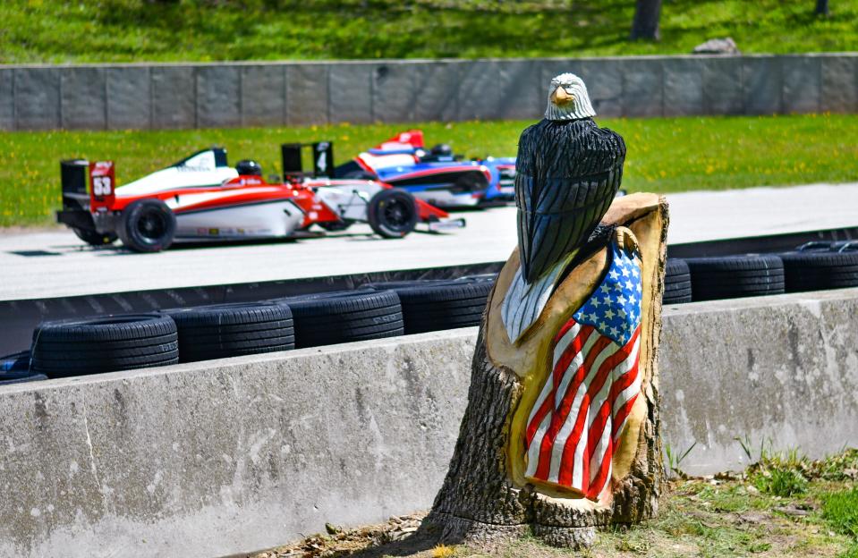 A bald eagle and American flag, carved by local artist Ben Buschke from the trunk of a dying tree that was removed, stands near Road America's Turn 12.