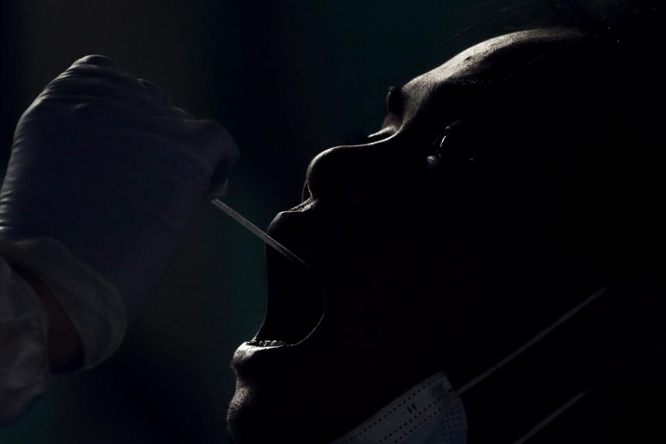 A resident undergoes a free COVID-19 swab test in a low income area in Manila, Philippines, Tuesday, Oct. 6, 2020. The city government is providing free swab tests to tricycle and passenger Jeepney drivers in the area in hopes of curbing the spread of the coronavirus. (AP Photo/Aaron Favila)