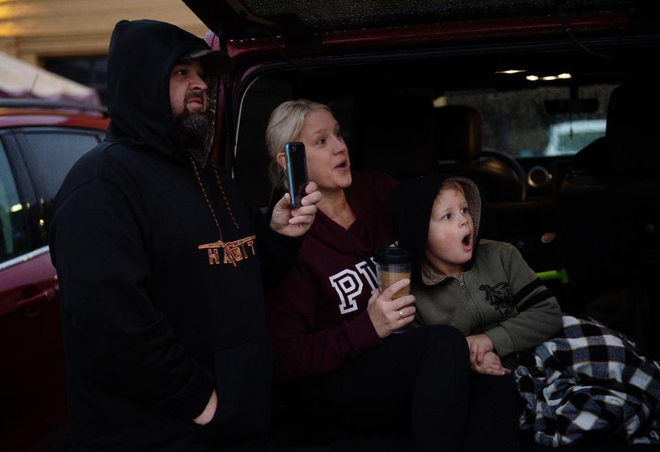 Greg Hebbeler of Evansville records the 420 Main building implosion with his girlfriend, Krystal Brown, and her son, Camilus, 5, from the tailgate of their SUV in Evansville on Sunday morning.