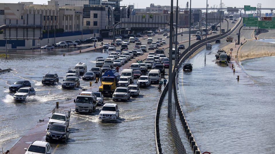I veicoli attraversano le acque alluvionali causate dalle forti piogge a Dubai giovedì.  - Christopher Pike/AP