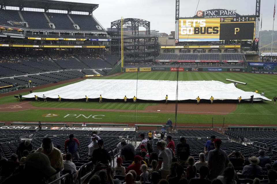 Grounds crew members pull the tarp on the field during a rain delay in the sixth inning of a baseball game between the St. Louis Cardinals and the Pittsburgh Pirates in Pittsburgh, Wednesday, Aug. 23, 2023. (AP Photo/Matt Freed)