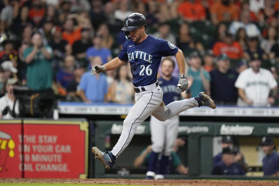 Seattle Mariners' Adam Frazier scores a run on Abraham Toro's two-run single during the ninth inning of the team's baseball game against the Houston Astros, Saturday, July 30, 2022, in Houston. (AP Photo/Eric Christian Smith)