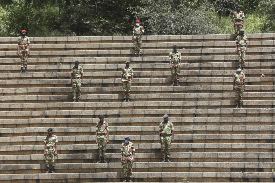 Soldiers practice social distancing during a state burial of government ministers who died of COVID-19, in Harare, Thursday, Jan. 21, 2021. Zimbabwean President Emmerson Mnangagwa who presided over the burial called the pandemic "evil" and urged people to wear masks, practice social distancing and sanitize, as cases across the country increased amid a fragile health system. (AP Photo/Tsvangirayi Mukwazhi)