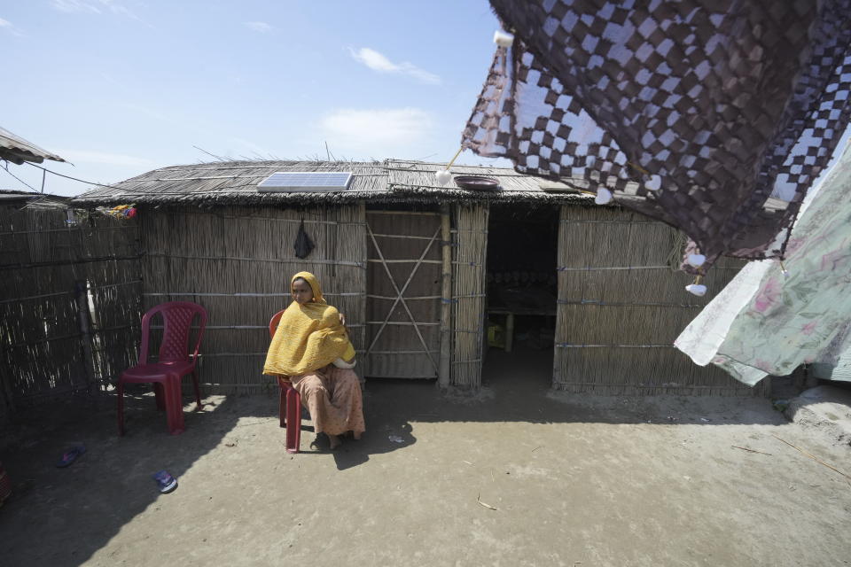 25-year-old Jahanara Khatoon, who is at full-term pregnancy, sits holding her daughter in Sandoh Khaiti Char, in the northeastern Indian state of Assam, Wednesday, July 3, 2024. (AP Photo/Anupam Nath)