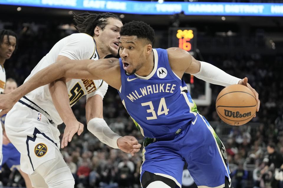Milwaukee Bucks' Giannis Antetokounmpo is fouled by Denver Nuggets' Aaron Gordon during the second half of an NBA basketball game Wednesday, Jan. 25, 2023, in Milwaukee. The Bucks won 107-99. (AP Photo/Morry Gash)