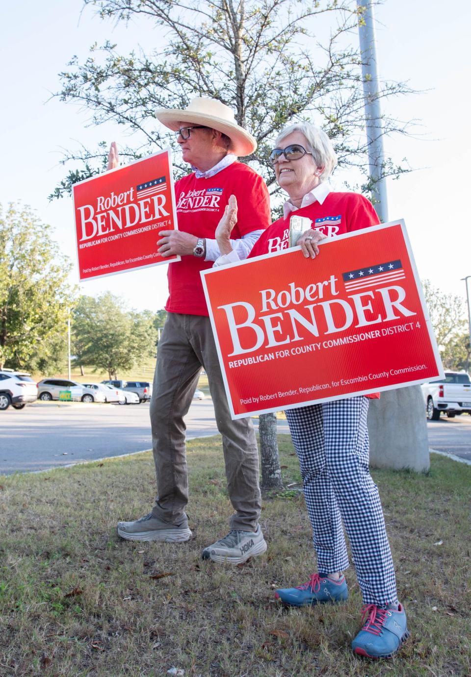 Jim Rigsbee, left, and Ginger Bender wave and hold campaign signs for incumbent Escambia County Commissioner District 4 candidate Robert Bender in the parking lot at the Bayview Community Center on Election Day in Pensacola on Tuesday, Nov. 8, 2022.