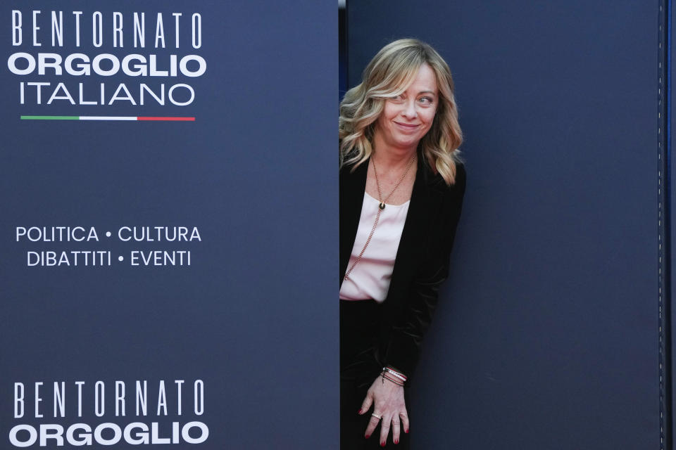 Italy's Prime Minister Giorgia Meloni peers out from a door before introducing Britain's Prime Minister Rishi Sunak at the annual political festival Atreju, organized by the Giorgia Meloni's Brothers of Italy political party, in Rome, Saturday, Dec. 16, 2023. (AP Photo/Alessandra Tarantino)