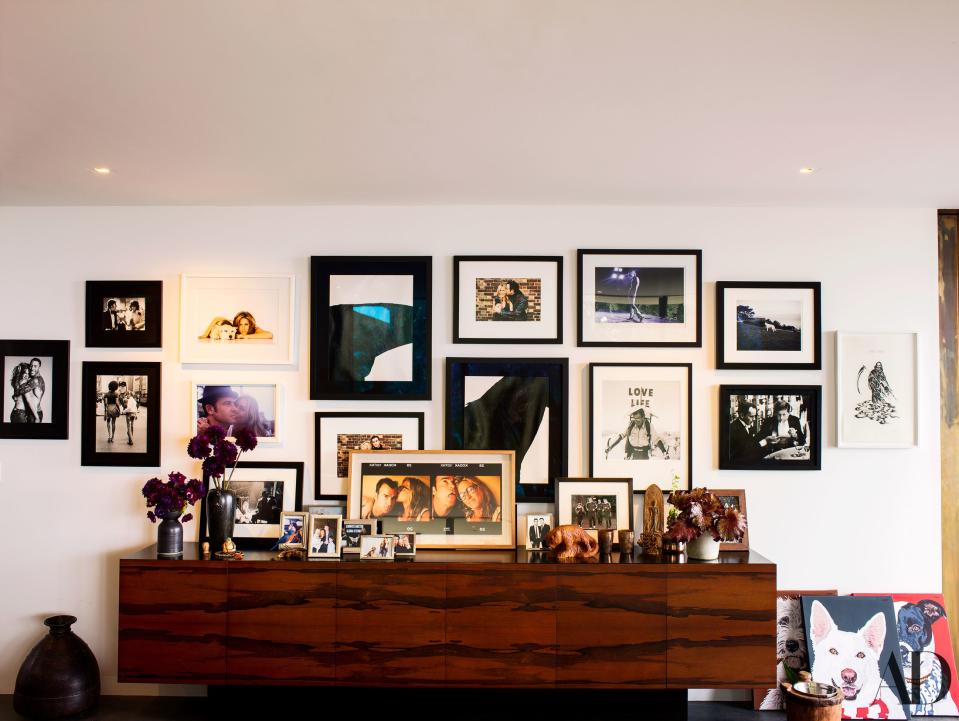 Pictures of the couple stand on a vintage rosewood credenza in the family room. Other photographs from Staley-Wise Gallery.