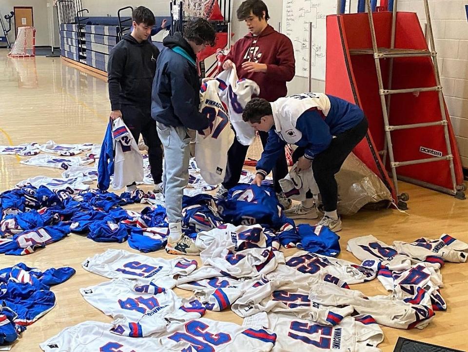 From left, Winnacunnet's Jonathan Vigeant, Daniel Blankenship, Kaleb Joiner and Jack Hogan search for their jerseys Sunday, Nov. 20, 2022. The Warriors will play at Lowell, Massachusetts, on Thanksgiving.