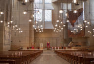 FILE - In this April 10, 2020 file photo, the Cathedral of Our Lady of the Angels is seen empty without its congregation on Holy Friday, as Los Angeles Archbishop Jose H. Gomez, second from left, leads the nation's Catholics in praying during a National Moment of Prayer in Los Angeles. The California Department of Public Health released a framework under which county health departments can approve the reopening of churches, mosques, synagogues and other houses of worship that have mostly shuttered their doors since Gov. Gavin Newsom's March stay-at-home order designed to slow the spread of the coronavirus. California churches can resume in-person services but worshippers will be limited to 100 people and they should wear masks, avoid sharing prayer books and skip the collection plate under state guidelines released Monday, May 25. (AP Photo/Damian Dovarganes, Pool)