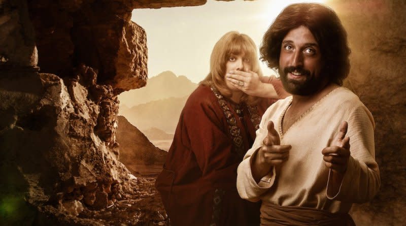 Jesus ~(front right) with a 'friend' beleived to be lover (behind) stand in a cave while Jesus points finger guns at the camera and the friend covers his mouth in promotional image for Netflix show